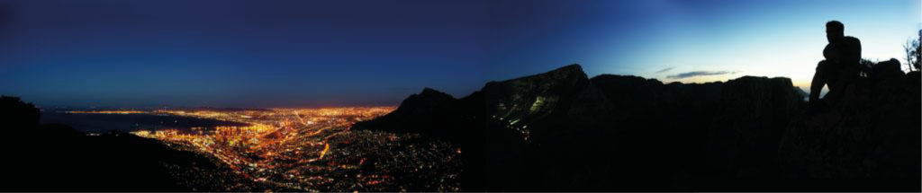 Nacht-Panorama auf dem Lion’s Head mit Blick auf Kapstadt’s Lichtermeer (links) und den angestrahlten Tafelberg während des letzten Lichtscheins der untergehenden Sonne auf der Meerseite (rechts) – Fotografiert von Peter Becker